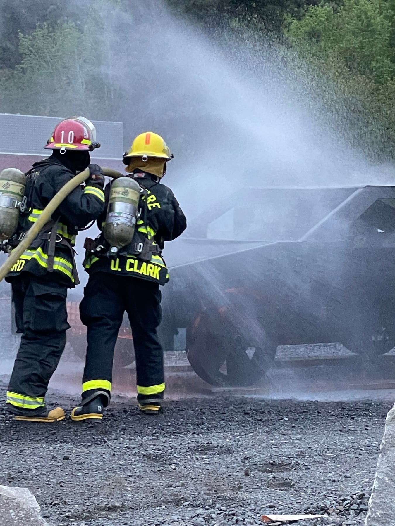 Firefighters advance hose lines together during live-fire training