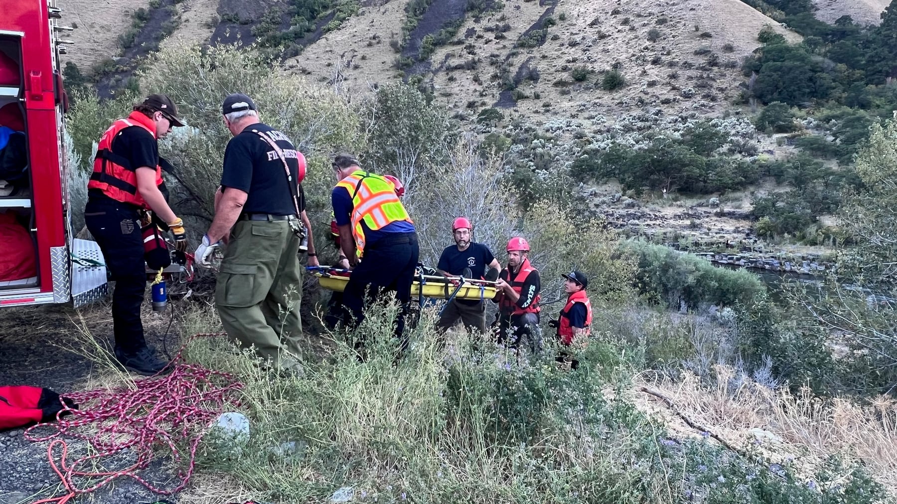 Technical rescue members work together during a rope-rescue operation in steep terrain