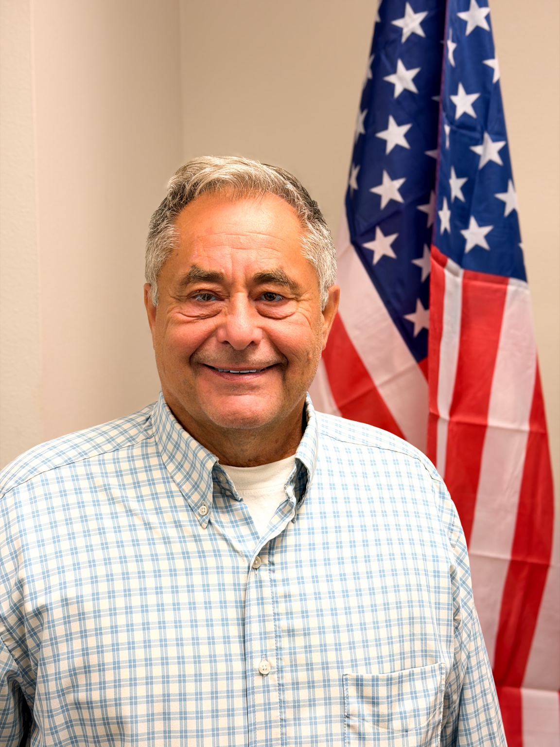 Commissioner Jim Fretwell, Chairman of the Board, standing in front of an American flag