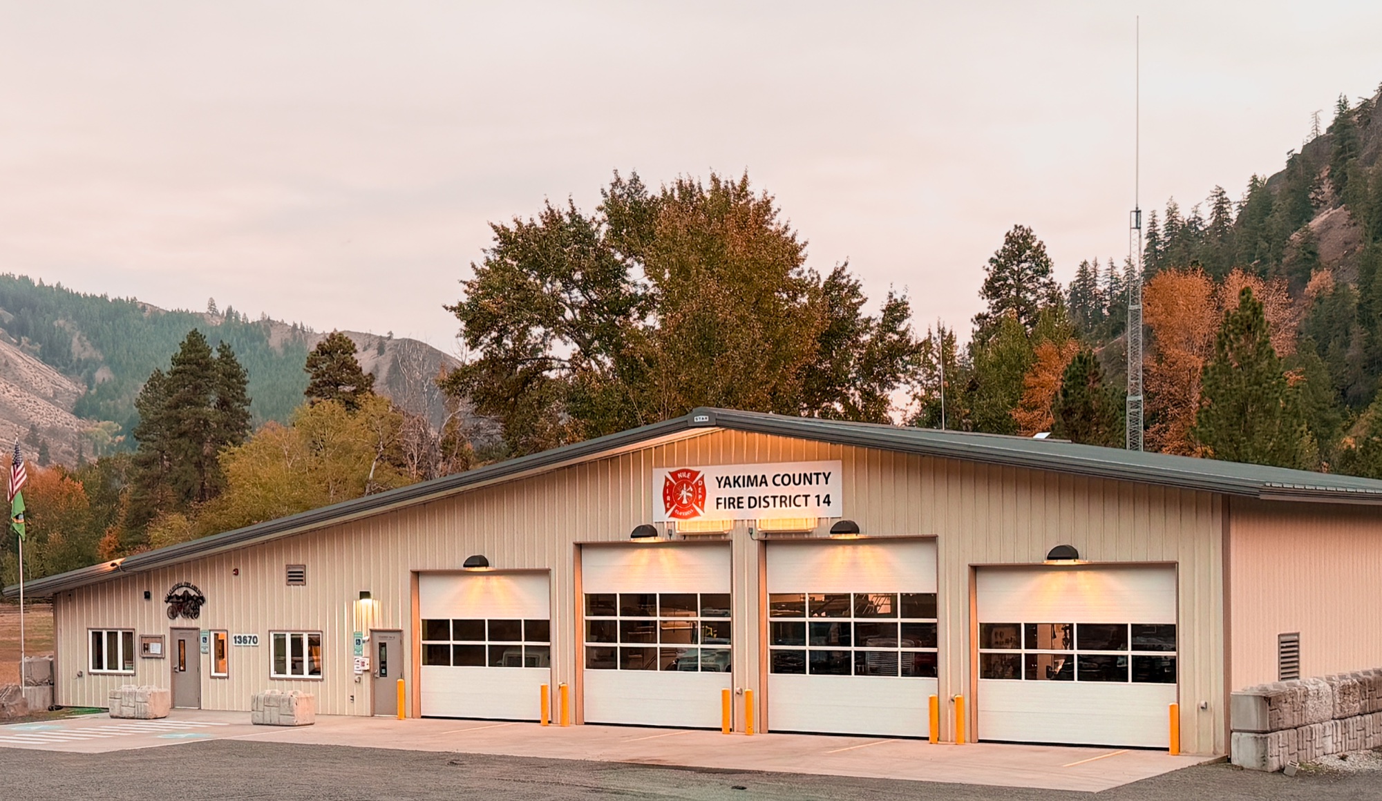 Station 11 headquarters exterior at dusk with autumn trees and the Nile Valley mountains behind it